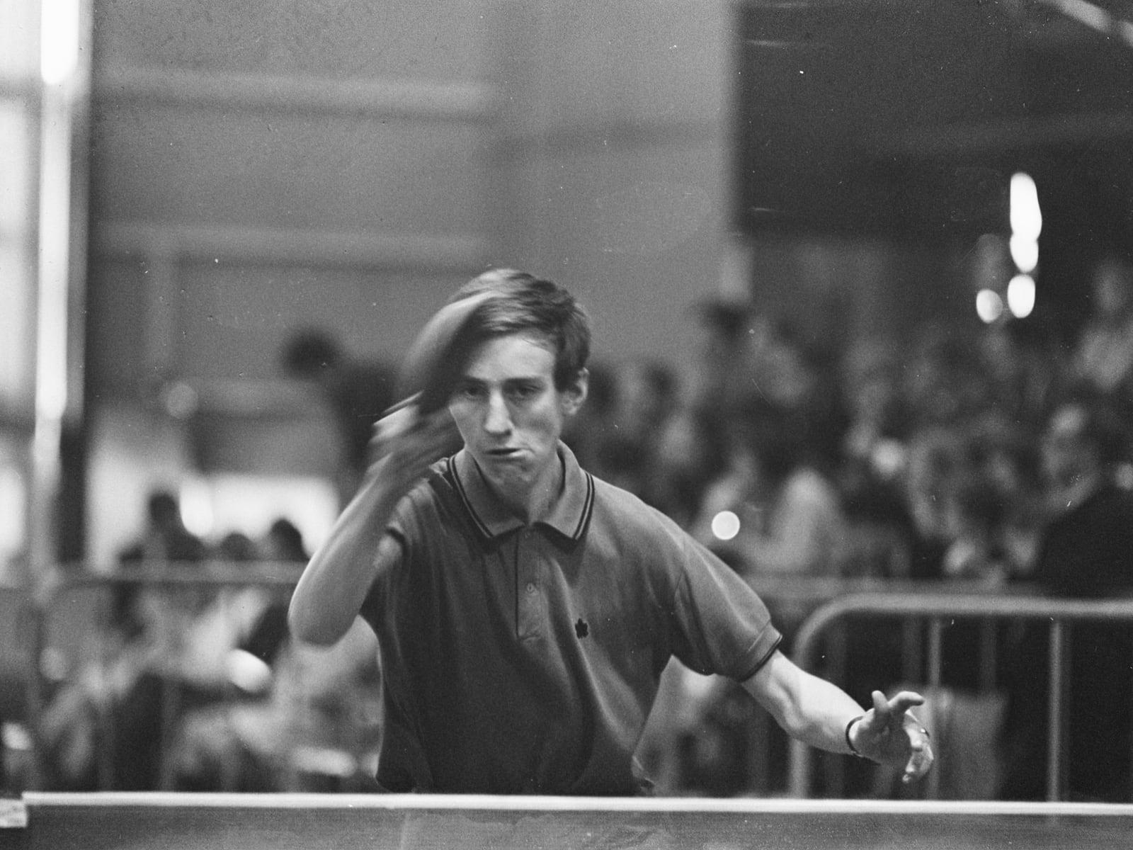 A table tennis player mid-stroke at a championship table, 1968